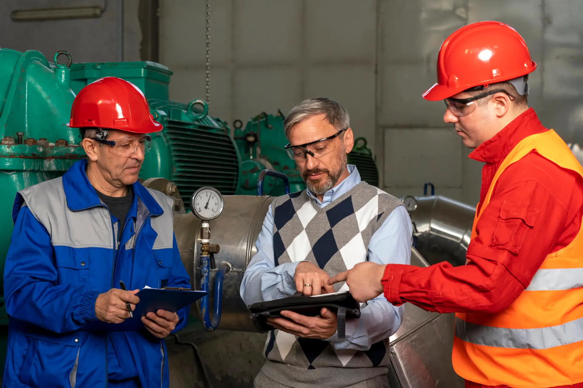 Menedżer techniczny i operatorzy SCADA omawiają proces produkcji w zakładzie przemysłowym
